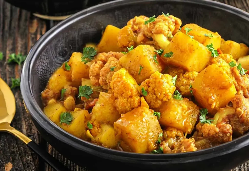 Plate of flavorful aloo gobi garnished with fresh cilantro.