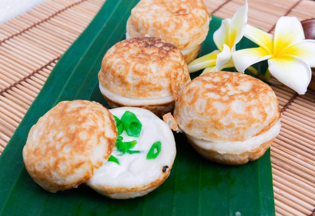 Kanom Krok yang lezat dan kenyal, dengan topping jagung manis dan daun bawang, siap untuk dinikmati selagi hangat
