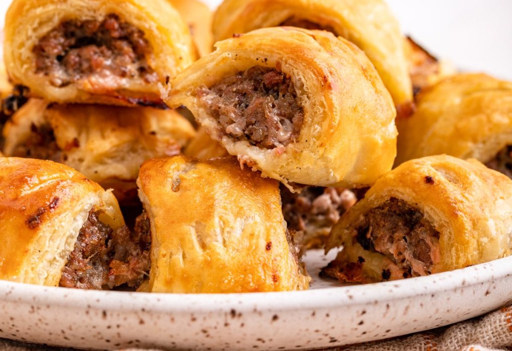 Close-up of freshly baked sausage rolls with golden flaky pastry.
