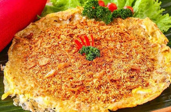 Kerak Telor: Dari Festival Betawi hingga Pariwisata Internasional Kerak telor khas Betawi sedang dimasak dengan sempurna di atas wajan kecil, menampilkan tekstur garing dan aroma gurih yang menggoda