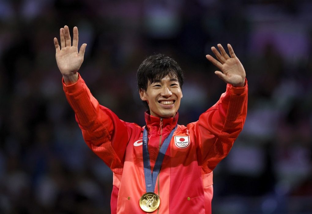 Japanese athlete celebrating gold medal victory at Paris 2024 Olympics.